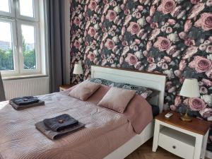 - une chambre avec un lit et un papier peint floral dans l'établissement Trzynastka, à Chorzów
