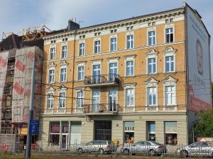 a large building with cars parked in front of it at Trzynastka in Chorzów