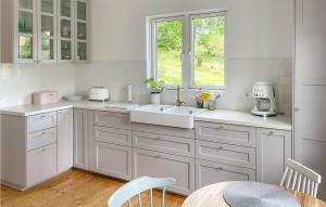 cocina con armarios blancos, fregadero y ventana en Nice Home In Edsbruk With Kitchen en Edsbruk