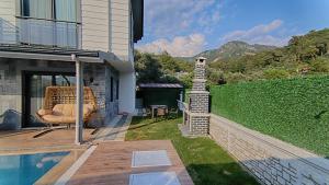 a patio with a chair and a swimming pool at Göcek Villa Can in Belenpınar