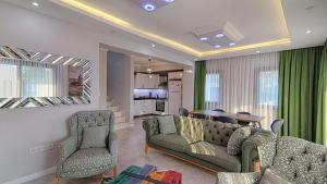 a living room with a couch and chairs and a table at Göcek Villa Can in Belenpınar