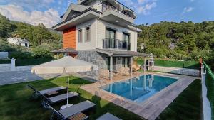 a house with a swimming pool in the yard at Göcek Villa Can in Belenpınar