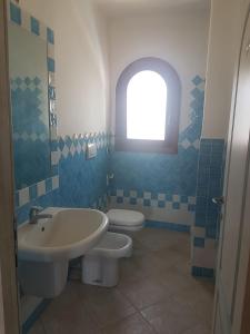 ein Bad mit einem Waschbecken, einem WC und einem Fenster in der Unterkunft Villa Cala d'Oro santa teresa di gallura in Santa Teresa Gallura