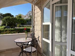 a balcony with a table and chairs and a window at Apartments Gordana Buzolic in Hvar