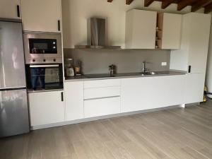 cocina grande con armarios y electrodomésticos blancos en Apartamentos rurales La Teyeruca II en Posada de Llanes