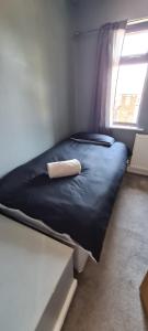 uma pequena cama num quarto com uma janela em Thorpe House Suites em Heeley