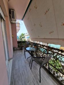 einen Balkon mit einem Tisch und Stühlen auf einem Gebäude in der Unterkunft Cozy Little Home in Athen