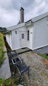 two benches sitting in front of a building at Leilighet v Hardangerfjorden in Hesthamar