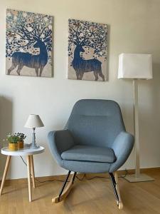 a blue chair in a room with a table and a lamp at Πολυτέλεια και ηρεμία στο κέντρο των Β.Προαστίων.. in Athens