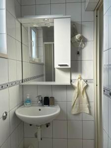 a white bathroom with a sink and a mirror at Apartments Gordana Buzolic in Hvar