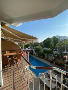 a balcony with a table and a swimming pool at Tulip Apart Hotel in Ortaca