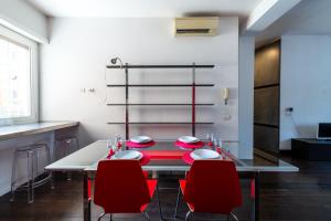 a dining room with a table and red chairs at Casa di Ele in Rome