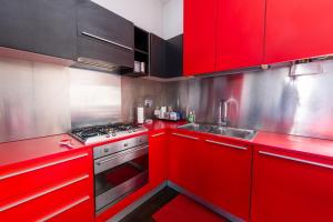 Casa di Ele في روما: مطبخ احمر مع موقد ومغسلة