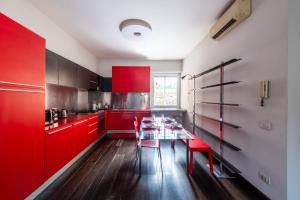 a red kitchen with a table and red cabinets at Casa di Ele in Rome