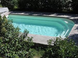 a swimming pool with green water in a yard at Arum in Codalet