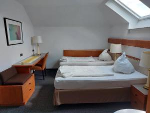 Una habitación de hotel con dos camas y un escritorio y un escritorio. en Gästezimmer Gasthof Becker, en Wülfrath