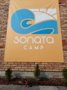 亞斯塔爾尼亞的住宿－Sonata Camp，砖墙上一个圣克拉拉营地的标志