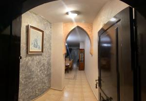 a hallway with an archway in a house with a table at Appartement AP2 Résidence Al Waha in Saidia 