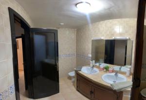 ein Badezimmer mit zwei Waschbecken und einem großen Spiegel in der Unterkunft Appartement AP2 Résidence Al Waha in Saidia 