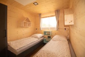 two beds in a small room with a window at Camp Ante-Gojko in Grebaštica