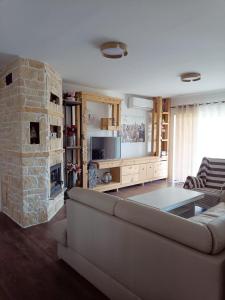ein Wohnzimmer mit einem Sofa und einem Steinkamin in der Unterkunft Vacation House Rosa in Supetarska Draga