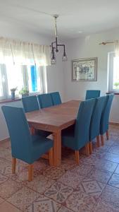 einen Holztisch und blaue Stühle in einem Zimmer in der Unterkunft Vacation House Rosa in Supetarska Draga