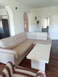 ein Wohnzimmer mit einem weißen Sofa und einem Tisch in der Unterkunft Vacation House Rosa in Supetarska Draga