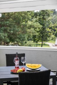 - une table avec une assiette de fruits et des verres à vin dans l'établissement Balatonic Lemon apartmanház, à Siófok