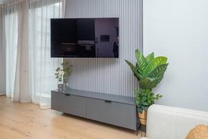a living room with a tv on a wall at Elegant Green Point Apartment in Cape Town