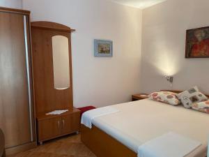 a small bedroom with a bed and a mirror at Apartments Gordana Buzolic in Hvar
