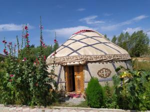 una pequeña casa en una cúpula en un jardín con flores en Guest House Doktor Eismann en Chychkan