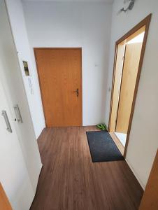 een lege hal met een houten deur en een tapijt bij Ferienwohnung Monteurswohnung Großräschen in Großräschen