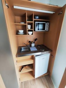 een keuken met een spoelbak en een magnetron bij Ferienwohnung Monteurswohnung Großräschen in Großräschen