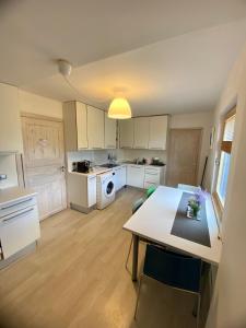 a kitchen with white cabinets and a table in it at LillasLavender Kurzeme in Ošenieki
