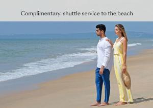 a man and a woman standing on the beach at Alila Diwa Goa - A Hyatt Brand in Majorda