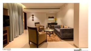 een woonkamer met een bank en een tafel en stoelen bij Cocoon Hotel in Pune