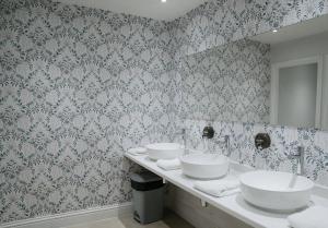 a bathroom with two sinks and a mirror at Highfield Hall in Mold