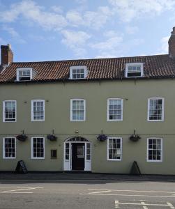 a large yellow building with a white door at Beaumond Cross Inn in Newark upon Trent