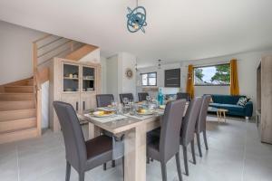 a dining room and living room with a table and chairs at Instants detente en famille au Tour-du Parc in Le Tour-du-Parc