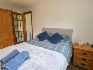a bedroom with a blue and white bed with blue pillows at Finnisterre in Holyhead
