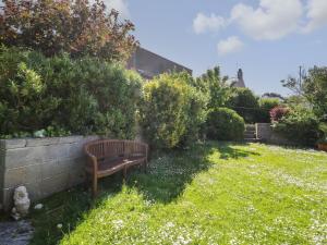 a bench sitting in the grass in a yard at Finnisterre in Holyhead