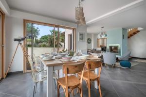 a dining room with a table and chairs at Villa Face Mer pour 10 personnes à Préfailles in Préfailles