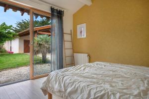 a bedroom with a bed and a sliding glass door at Villa Face Mer pour 10 personnes à Préfailles in Préfailles