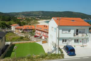 a blue van parked in a parking lot next to a house at El Pommier in Fisterra