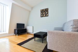 sala de estar con sofá y TV en Notting Hill Serviced Apartments by Concept Apartments, en Londres