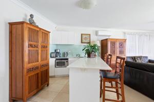 a kitchen with wooden cabinets and a white counter top at Waterfront on Manly Harbour in Sydney