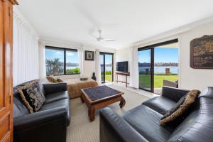 uma sala de estar com um sofá e uma mesa em Waterfront on Manly Harbour em Sydney