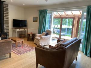 sala de estar con sofá, sillas y TV en Private detached cottage sleeps 4, en Crieff