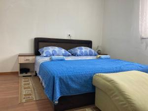 a bedroom with a bed with a blue comforter at Smestaj STE- LUK in Bajina Bašta