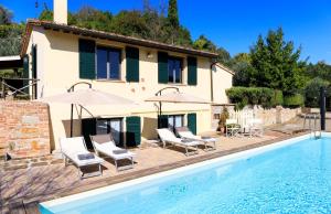 een huis en een zwembad met stoelen en parasols bij Casa Papa in Castelfiorentino